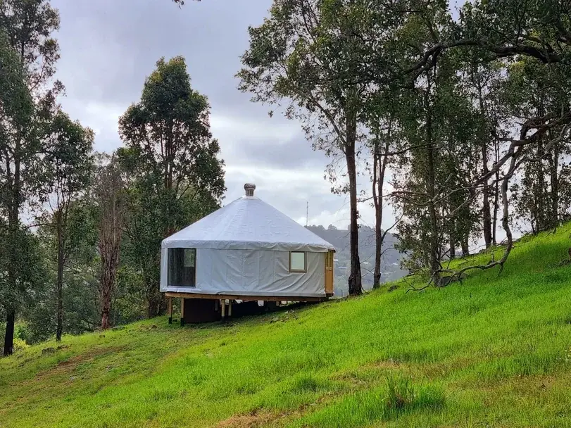 White 6.3m Yurt on a grassy slop in Balingup Western Australia
