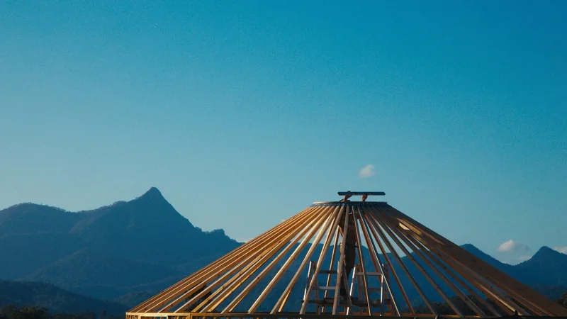 The ORON roof frame against a blue sky, with a mountain peak behind it